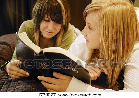 Two teens reading a Bible View Large Photo Image Stock Photo - Two teens reading a Bible. Fotosearch