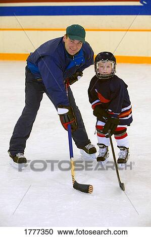 Stock Image - A coach and young hockey player. Fotosearch