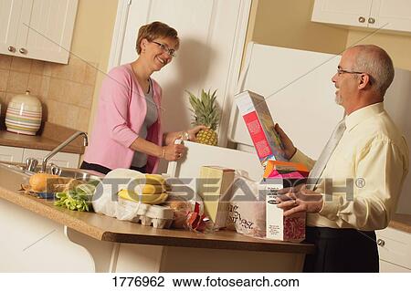 Stock Image - A couple unpacking groceries. Fotosearch