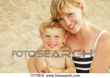 Picture - A mother holding her child at the beach. Fotosearch