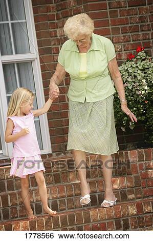 Child walks down steps with senior View Large Photo Image Stock Photograph - Child walks down steps with senior. Fotosearch