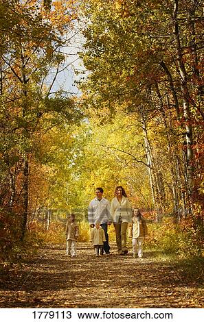 Stock Image - Family walking in fall leaves. Fotosearch