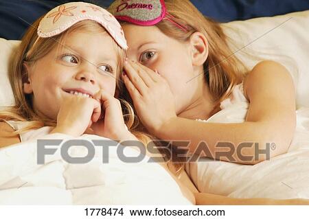Girls whispering in bed View Large Photo Image Picture - Girls whispering in bed. Fotosearch