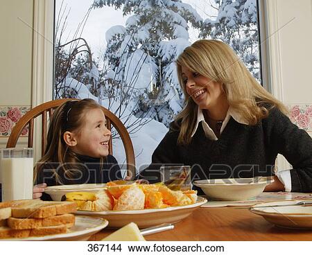 Mother daughter smile at breakfast table View Large Photo Image Picture - Mother daughter smile at breakfast table. Fotosearch