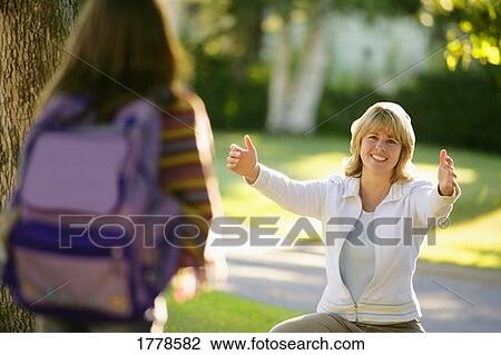 Stock Image - Mother welcomes child home from school. Fotosearch