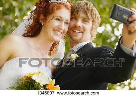 Newly married couple takes first photo View Large Photo Image Stock Photo - Newly married couple takes first photo. Fotosearch