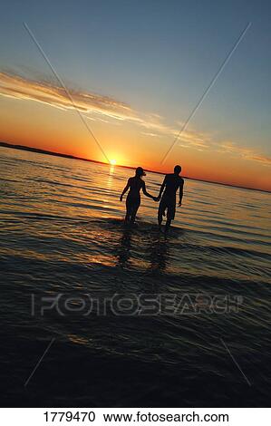 Stock Image - A couple walking in the water. Fotosearch