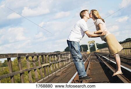 Couple kiss on the railroad tracks View Large Photo Image Stock Image - Couple kiss on the railroad tracks. Fotosearch