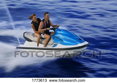 Stock Image - Couple on jet ski. Fotosearch