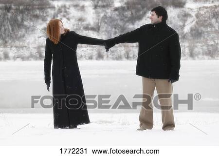 Couple standing in snow View Large Photo Image Stock Image - Couple standing in snow. Fotosearch