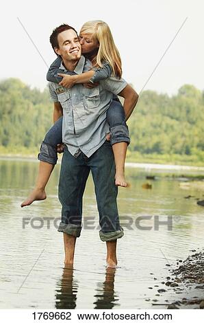 Stock Image - Giving her a piggy-back. Fotosearch