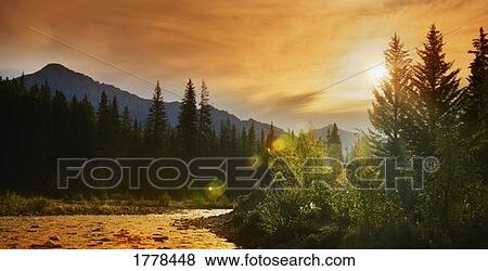 A river or stream against trees and mountains View Large Photo Image Stock Photo - A river or stream against trees and mountains. Fotosearch