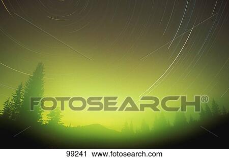 Stock Image - Start trails in the night sky with Northern Lights Alberta Canada. Fotosearch