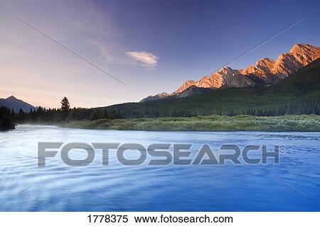 Stock Photography - Sunrise and early morning mist on river Elk Lakes. Fotosearch