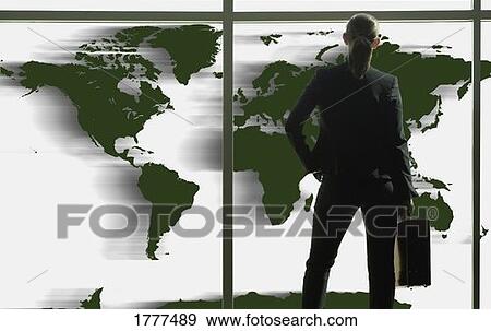 Stock Photo - Business woman looking at world map. Fotosearch