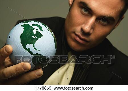 Stock Image - Businessman holds the world in his hand. Fotosearch