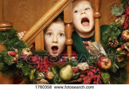Stock Photo - Children peek through decorated railing. Fotosearch