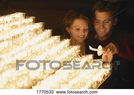 Young couple lighting a candle View Large Photo Image Stock Image - Young couple lighting a candle. Fotosearch
