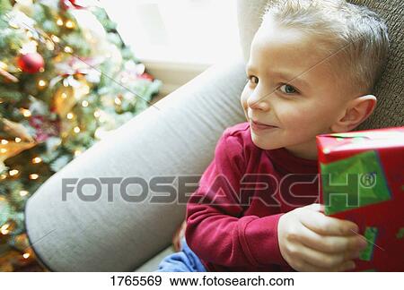 A child with a gift at Christmas View Large Photo Image Stock Photo - A child with a gift at Christmas. Fotosearch