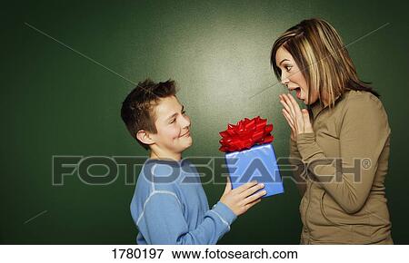 Boy gives a gift to girl View Large Photo Image Stock Photo - Boy gives a gift to girl. Fotosearch