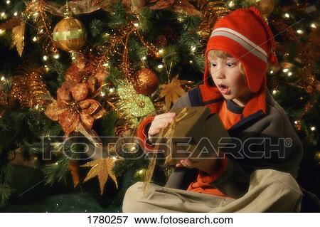 Child opening Christmas present View Large Photo Image Stock Photo - Child opening Christmas present. Fotosearch