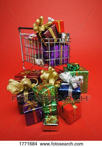Picture - Pile of presents near shopping cart. Fotosearch