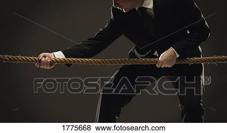 Stock Photo - Man in tug of war. Fotosearch