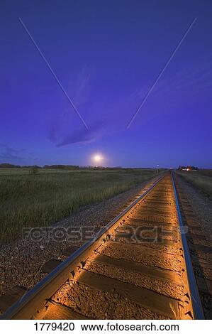 Stock Image - Train Tracks at Sunset in the prairies. Fotosearch