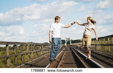 A couple walk on railroad tracks View Large Photo Image Stock Image - A couple walk on railroad tracks. Fotosearch