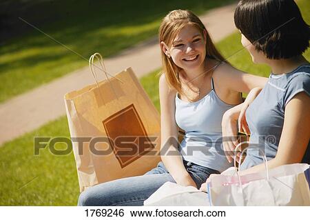 Girls sit on a bench View Large Photo Image Stock Photograph - Girls sit on a bench. Fotosearch