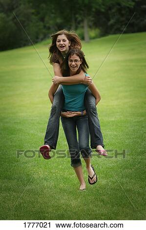 Stock Image - Two friends playing in a park. Fotosearch