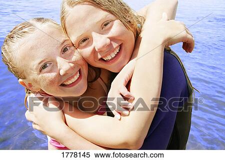 Two girls hug in the water View Large Photo Image Stock Photography - Two girls hug in the water. Fotosearch