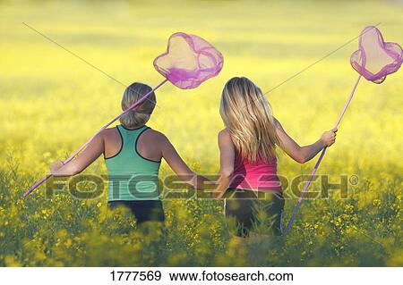 Two girls looking for butterflies View Large Photo Image Stock Photo - Two girls looking for butterflies. Fotosearch