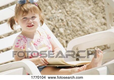 Picture - A child sits and reads. Fotosearch