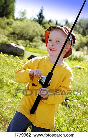 Stock Image - Boy reeling in a catch. Fotosearch