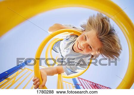 Stock Photo - Child hangs upside down. Fotosearch