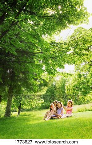 Four girls sitting on lawn View Large Photo Image Stock Photo - Four girls sitting on lawn. Fotosearch