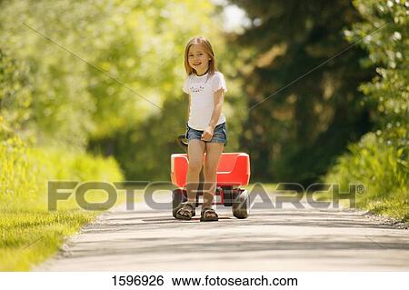 Stock Photograph - Girl pulls wagon. Fotosearch