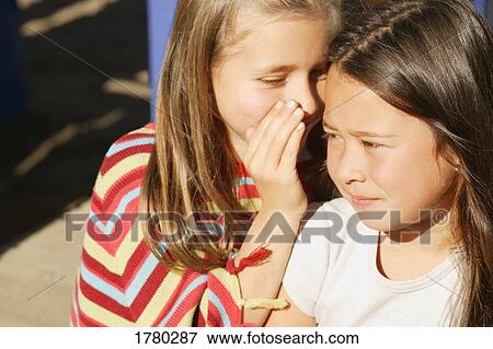 Girl tells a secret View Large Photo Image Stock Photo - Girl tells a secret. Fotosearch