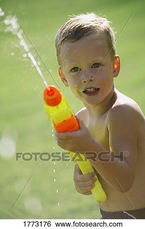 Stock Photograph - Little boy playing with a water shooter. Fotosearch