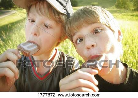 Stock Image - Two boys making funny faces while eating. Fotosearch