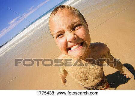 Stock Photo - Young boy making funny face on beach. Fotosearch
