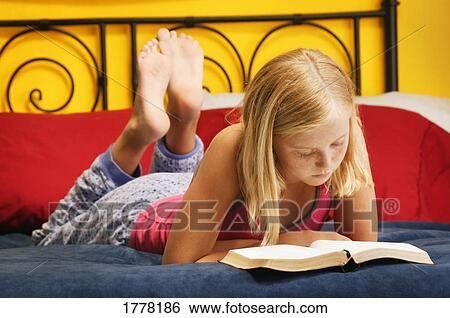 Young girl reading bible on bed View Large Photo Image Stock Photograph - Young girl reading bible on bed. Fotosearch