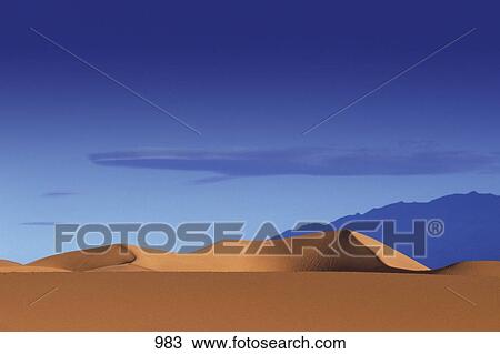 Stock Image - Large sand dune and mountain in the distance. Fotosearch