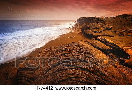 Stock Image - Rocky coastline and incoming tide. Fotosearch