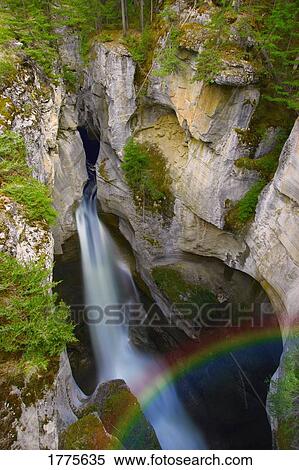 Waterfall in cliffs with rainbow View Large Photo Image Stock Photography - Waterfall in cliffs with rainbow. Fotosearch