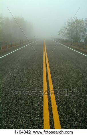 Stock Image - A highway that leads into fog. Fotosearch