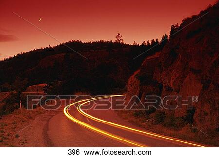 Stock Photograph - Time delay of headlights on a mountain road. Fotosearch