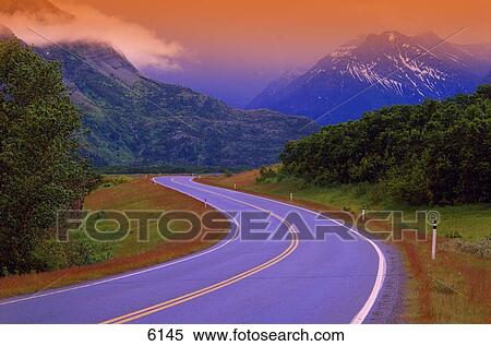Stock Photography - Two lane country road in mountains after rain. Fotosearch
