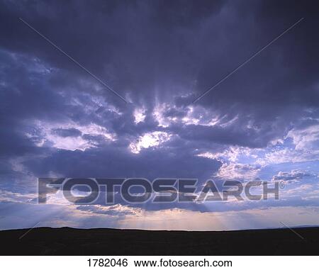 Blue sky with sun rays peeking through cloud View Large Photo Image Stock Photograph - Blue sky with sun rays peeking through cloud. Fotosearch